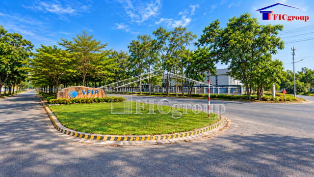 Main entrance area of VFIP Industrial Park featuring the VFIP monument sign, landscaped green spaces, tree-lined internal roads, and industrial buildings.